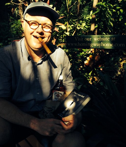 Lars Østergaard sidder på en bænk foran Hemmingway-museet med sin bog i hånden